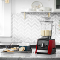 Vitamix A2500i czerwony z dzbankiem pełnym kremu obok domowych ciasteczek – ilustracja łatwości blendowania wypieków